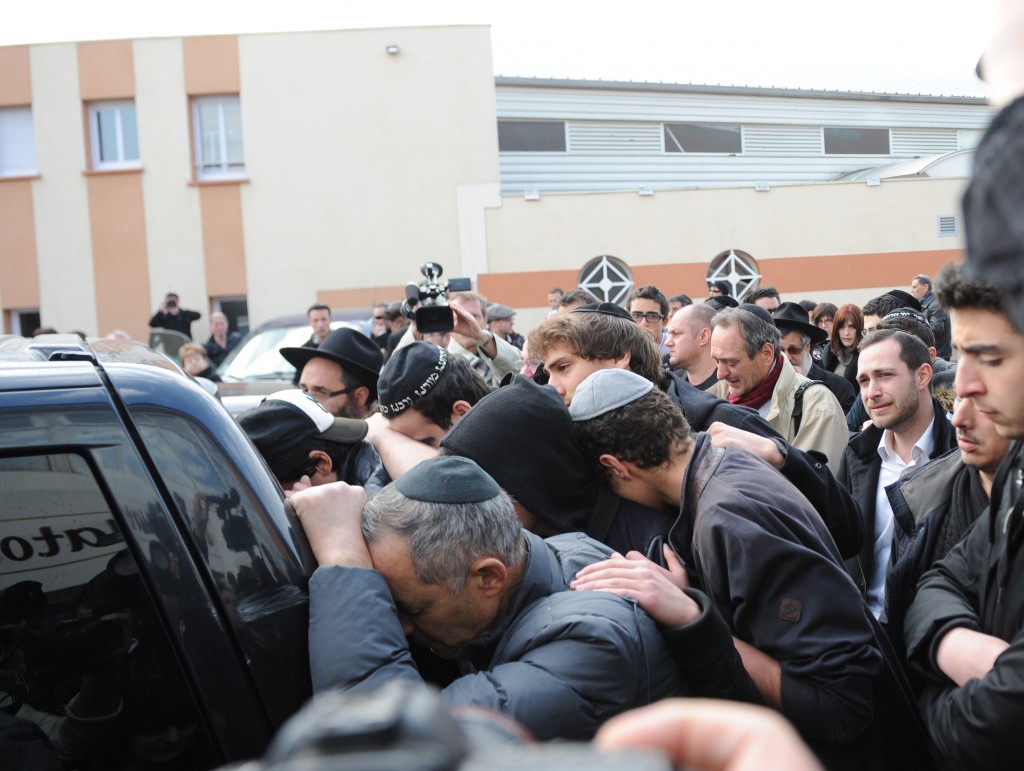 Mourners follow a hearse after a memorial ceremony