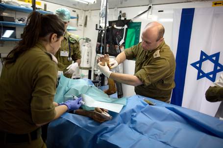 Israeli medics treat a wounded Syrian man at a field hospital