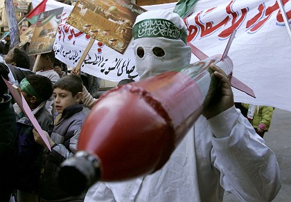 A Hamas supporter carries a mock Qassam rocket